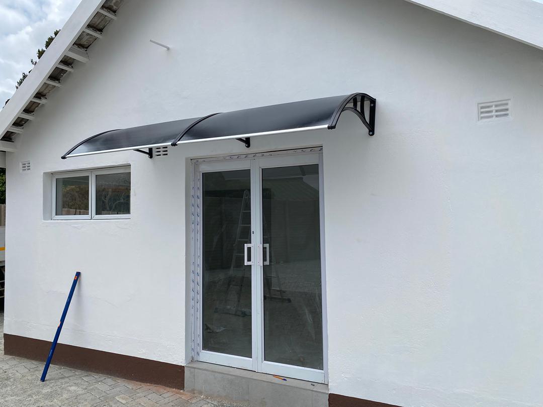 Curved black door canopy above patio doors