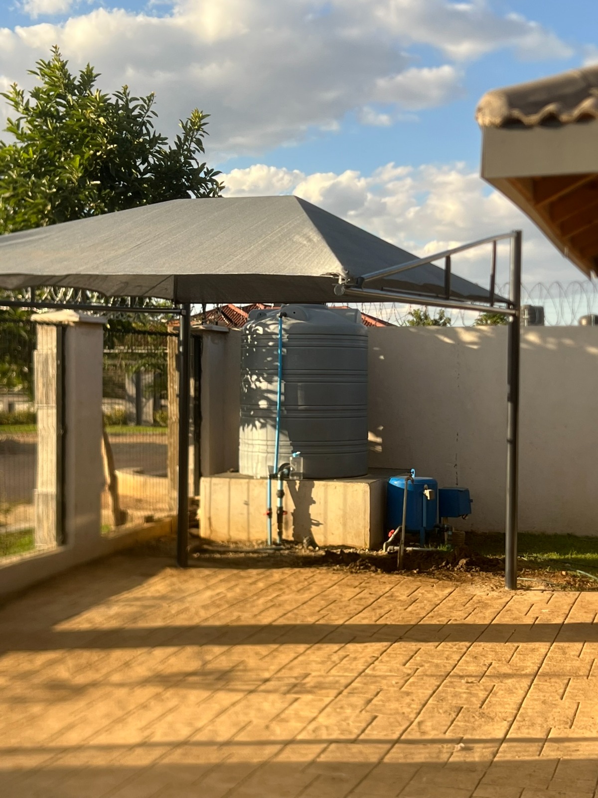 Shade-net structure covering a water tank